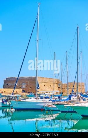 Marina in Heraklion. Segelyachten mit hohen Masten im Hafen bei der venezianischen Festung an sonnigen Sommertagen, Kreta Insel, Griechenland Stockfoto