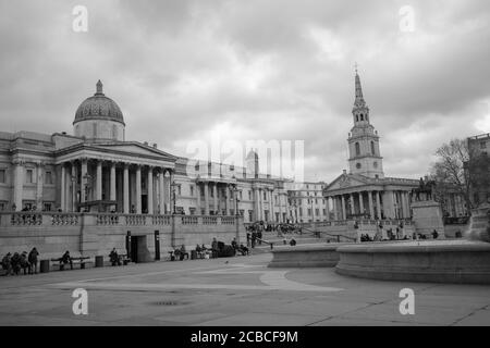 Schwarz-Weiß-Bild und Gesamtansicht des Trafalgar Square London mit der National Gallery Museum und St. Martin in den Feldern im Hintergrund. Stockfoto