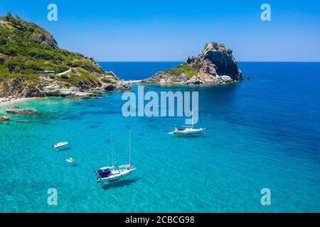 Boote auf klarem Wasser vor dem 'Mamma Mia Cliff', Skopelos, Nordsporaden, Griechenland Stockfoto