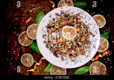 Müsli mit getrockneten Früchten, Mohn, Kalk auf Holzgrund Stockfoto