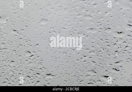 Textur von Bokeh Tropfen auf Glas vor dem Himmel Stockfoto