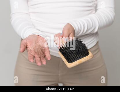 Haarausfall Problem, postpartale Periode, Menstruationsstörung, Stress. Viele Haare fallen nach dem Kämmen in Haarbürste Stockfoto