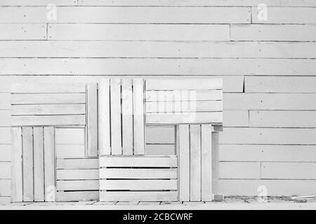 Weiße Holzkisten übereinander gestapelt vor dem Hintergrund einer weißen Holzwand, der konzeptionelle Hintergrund der Landschaft der Bretter und li Stockfoto