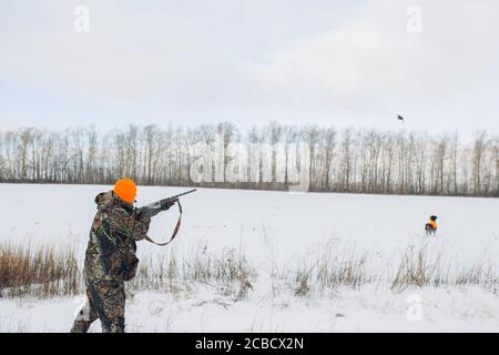 Junger Mann in speziellen Kleidern mit dem Ziel, fliegenden Vogel während der Jagd. Seitenansicht Foto. Copy space Stockfoto