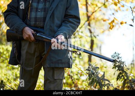 Waldjagd auf Tiere. Älterer Mann mit Schrotflinte, geht zur Jagd Stockfoto