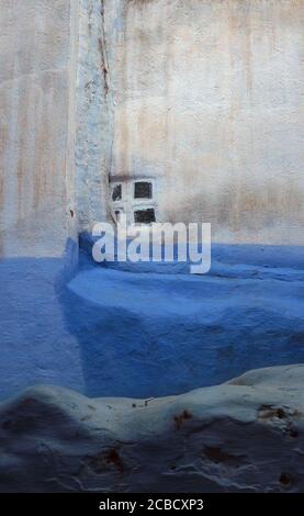 Wand eines alten traditionellen Hauses mit einem kleinen Fenster in der Medina von Chefchaouen, vertikales Panorama, Marokko Stockfoto