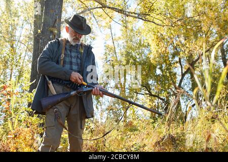 Jäger Mann laden Gewehr, Schrotflinte gehen auf wilde Tiere zu schießen. Jagd als Hobby Stockfoto