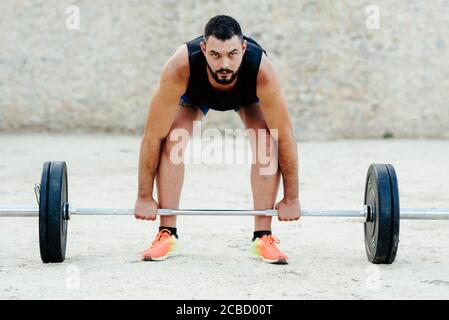 Gewichtheber mit Bart Gewichte heben in einer städtischen Umgebung. Stockfoto