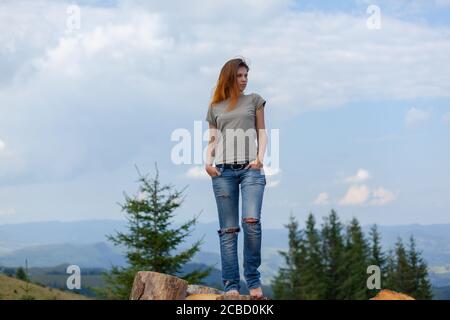 Mädchen in einem T-Shirt und Jeans posiert im Sommer Hoch in den karpaten Stockfoto
