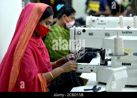 Dhaka. August 2020. Am 12. August 2020 arbeiten Menschen in einer Bekleidungsfabrik in Dhaka, Bangladesch. Die Exporteinnahmen in Bangladesch lagen im Juli um mehr als 44 Prozent höher als im Juni, was bedeutet, dass der Exportsektor des Landes nach schweren Schlägen aufgrund der COVID-19-Auswirkungen wieder zur Normalität zurückhinkt. Von den Gesamtergebniss ergab die Daten des Export Promotion Bureau (EPB), dass die Einnahmen des Landes aus Fertigwaren, einschließlich Strickwaren und Gewebe, bei 3.24 Milliarden US-Dollar lagen. Quelle: Xinhua/Alamy Live News Stockfoto