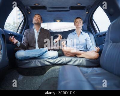 Geschäftsmann Und Assistent Tun Yoga Sitzen In Limousine Auto Stockfoto