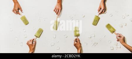 Damen Hände mit grünen Matcha Kokosnussblatten auf weißem Hintergrund Stockfoto