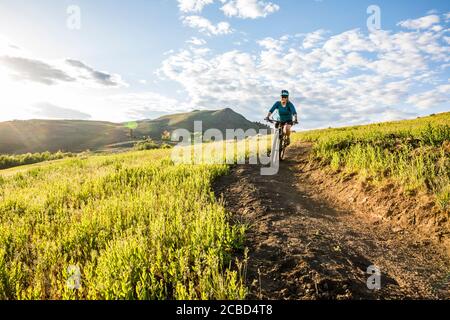 Eine Frau, die an einem sonnigen Nachmittag im Mai den Trail auf Lewis Butte außerhalb von Winthrop, Washington, bestieg. Stockfoto