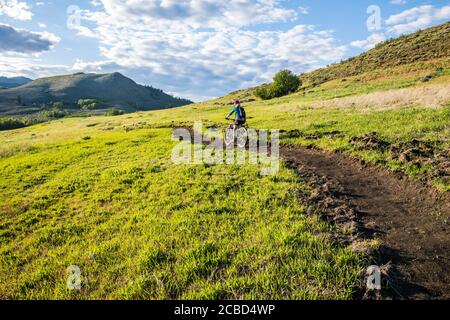 Eine Frau, die an einem sonnigen Nachmittag im Mai den Trail auf Lewis Butte außerhalb von Winthrop, Washington, bestieg. Stockfoto