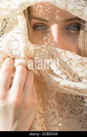 Junge Frau mit blauen Augen mit Schal über ihrem Gesicht Stockfoto