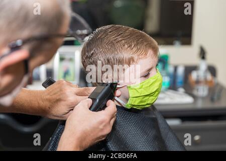 Person trägt Gesichtsmaske im Friseurladen Stockfoto