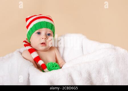 Hübsches Baby liegt auf weichem Stoff in der weißen Box. Frohe Weihnachten Stockfoto