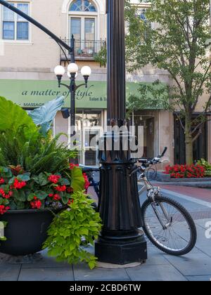 Pflanzgefäß und Fahrrad lehnt sich an Lampenstange. Marion Street, Innenstadt von Oak Park, Illinois. Stockfoto
