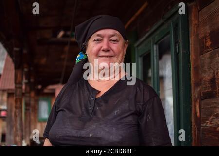 Maramures / Rumänien - 28. August 2019: Porträt einer lächelnden rumänischen Bauernfrau mit schwarzem Kopftuch Stockfoto