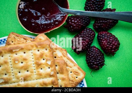 Frische Marmelade mit Cookies auf einem Teller auf einem grünen Oberfläche Stockfoto