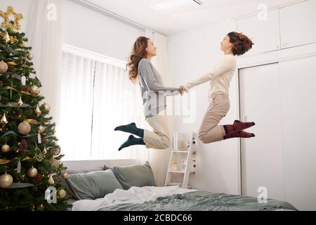 Glückliche Kinder springen, Spaß haben, spielen auf dem Bett im Schlafzimmer genießen des Morgens Stockfoto