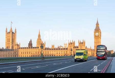 London, Großbritannien - 23. April 2014: Ein Notfall-Krankenwagen fährt bei Sonnenaufgang auf der Westminster Bridge. Im Hintergrund das Parlament und der Big Ben Tower. Stockfoto