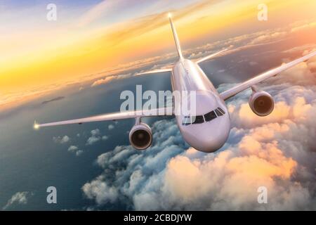 Commercial Airplane Flugzeug über den Wolken im schönen Abendlicht fliegen. Konzept für Reise und Business. Stockfoto