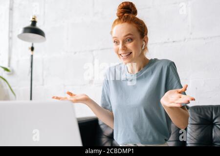 Glücklich überrascht Rotschopf junge Frau schaut auf Laptop-Bildschirm Mit verblüffenden Ausdruck Stockfoto