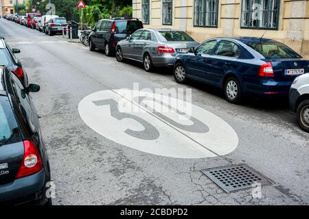 Das Standard, typisch, ikonisch bemalte kreisförmige 30km/h Geschwindigkeitsbegrenzungsschild auf einer Straße in der Nachbarschaft. In Wien, Österreich. Stockfoto