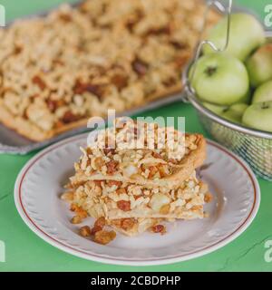 Hausgemachte schlanke Apfelkuchen Torte mit Rosinen und geriebenen gekühlten Teig, serviert auf dem Tisch im Sommer Pavillon Stockfoto