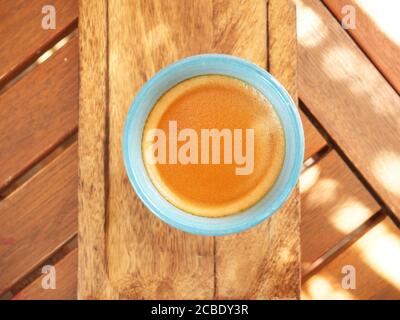 Nahaufnahme einer Kaffeetasse von oben auf einem Holztisch Stockfoto