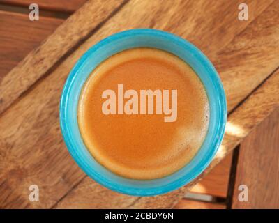 Nahaufnahme einer Kaffeetasse von oben auf einem Holztisch Stockfoto