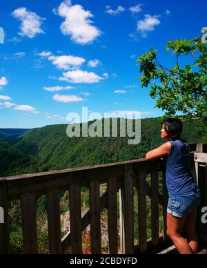 Eine afro-asiatische Frau von hinten betrachtet bewundert die Berglandschaft. Während der Ferien, Touristen gerne eine Pause machen, um die natürliche zu bewundern Stockfoto