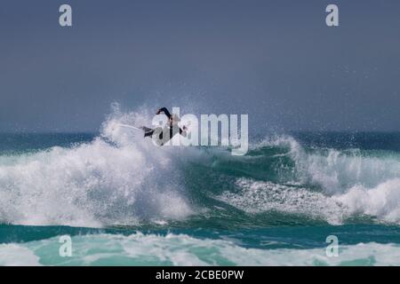 Wild spektakuläre Surfaktion als Surfer reitet eine Welle am Fistral in Newquay in Cornwall. Stockfoto