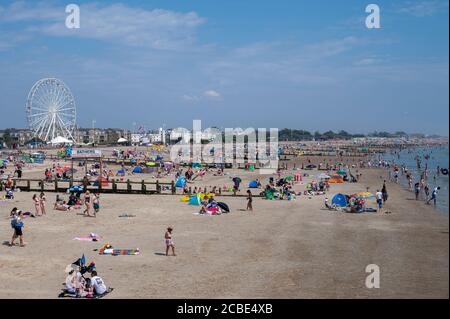 Littlehampton, West Sussex, Großbritannien, 12. August 2020. Tourist am Strand von Littlehampton mit dem Riesenrad auf dem Grün. Stockfoto