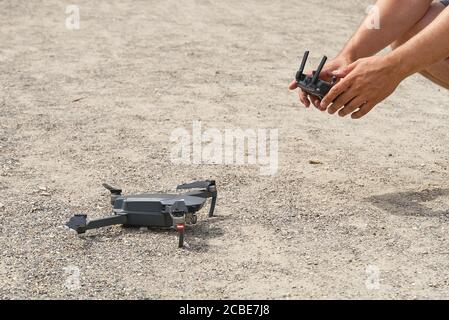 Mann mit Fernbedienung zu bedienen Drohne zuweisen verschwommenes Land. Stockfoto