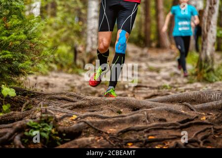 Beine Mann Läufer in Kompressionssocken und Kinesio Taping auf Knee Run Waldlehrpfad Stockfoto