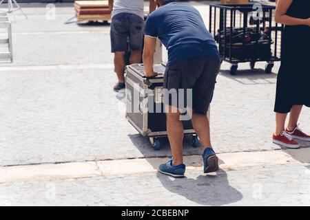 Be- und Entladen von Konzertgeräten. . Man steuert die Beladung von Gerätekoffer. Stockfoto