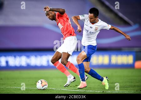 Der brasilianische Fußballspieler Anderson Souza Conceicao, bekannt als Anderson Talisca oder einfach Talisca, aus Guangzhou Evergrande Taobao F.C., links, schützt den Ball beim vierten Spiel der 2020 Chinese Super League (CSL) gegen Shandong Luneng Taishan F.C., Stadt Dalian, nordöstlich der chinesischen Provinz Liaoning, 9. August 2020. Guangzhou Evergrande Taobao F.C. wurde von Shandong Luneng Taishan mit 0:1 besiegt. Stockfoto