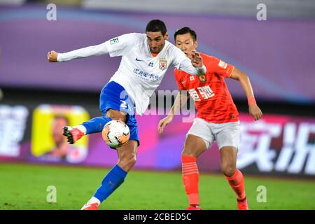 Die belgische Fußballspielerin Marouane Fellaini aus Shandong Luneng Taishan F.C., links, hält den Ball beim vierten Spiel der 2020 Chinese Super League (CSL) gegen Guangzhou Evergrande Taobao F.C., Stadt Dalian, nordöstlich der Provinz Liaoning, 9. August 2020. Guangzhou Evergrande Taobao F.C. wurde von Shandong Luneng Taishan mit 0:1 besiegt. Stockfoto