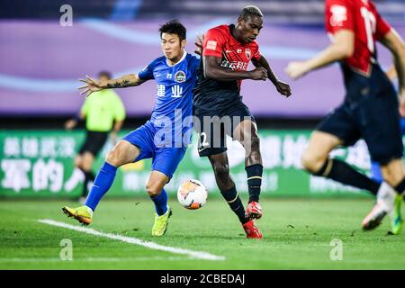 Der kamerunische Fußballspieler John Mary von Shenzhen F.C., rechts, kämpft beim vierten Spiel der chinesischen Super League (CSL) 2020 gegen Henan Jianye F.C., Dalian City, Nordost-Chinas Provinz Liaoning, 10. August 2020 um den Ball. Shenzhen F.C. wurde von Henan Jianye F.C. mit 1:2 besiegt. Stockfoto