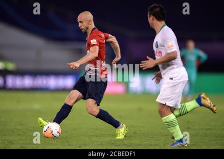 Der polnische Fußballspieler Adrian Mierzejewski von Chongqing SWM, links, schützt den Ball beim vierten Spiel der 2020 Chinese Super League (CSL) gegen Qingdao Huanghai F.C., Stadt Suzhou, ostchinesische Provinz Jiangsu, 11. August 2020. Qingdao Huanghai F.C. und Chongqing SWM zeichneten das Spiel mit 0:0. Stockfoto