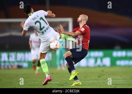 Der polnische Fußballspieler Adrian Mierzejewski von Chongqing SWM, rechts, wird beim vierten Spiel der chinesischen Super League (CSL) 2020 gegen Qingdao Huanghai F.C., Stadt Suzhou, ostchinesische Provinz Jiangsu, am 11. August 2020 getreten. Qingdao Huanghai F.C. und Chongqing SWM zeichneten das Spiel mit 0:0. Stockfoto