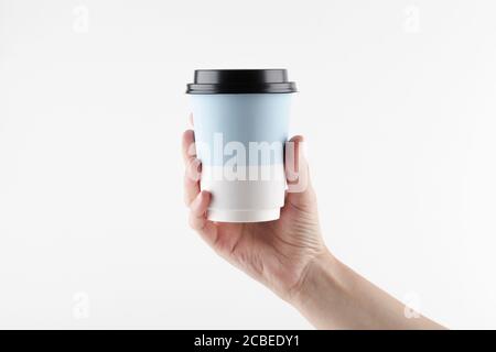 Mockup der Hand hält Take Away Papierbecher für Kaffee oder Tee auf weißem Hintergrund. Copy Space. Minimal Kaffee-Konzept. Stockfoto