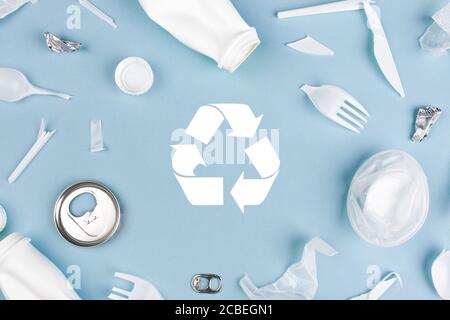 Draufsicht auf verschiedene Abfallstoffe mit Recycling-Symbol auf Blauer Hintergrund Stockfoto