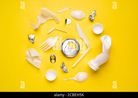 Verschiedene Arten von Plastikmüll. Lebensmittelverpackungen aus Kunststoff auf gelbem Hintergrund. Stockfoto