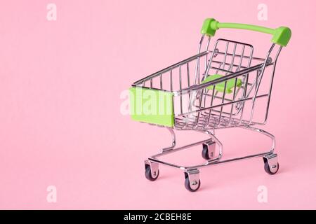 Leere Draufsicht Mini pink Warenkorb oder Trolley einkaufen Auf rosa Hintergrund Stockfoto