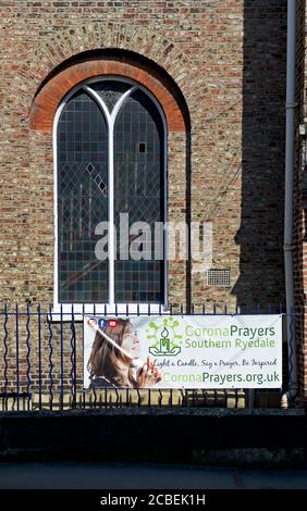 Banner vor der Kirche, die Menschen bitten, für die Opfer des Coronavirus zu beten, England Großbritannien Stockfoto