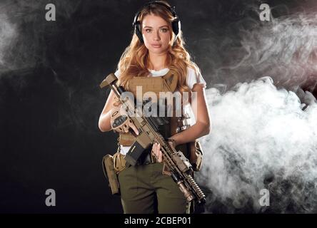 Frau in der Armee vor- und Nachteile. Frauen dienen nicht nur, sondern erreichen hohe Positionen und Ränge. Schöne Frau im Militär outholding Waffe in han Stockfoto