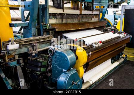 Johannesburg, Südafrika - 16. Oktober 2012: Nahaufnahme einer Baumwollfadenwebmaschine in einer Förderbandfabrik Stockfoto